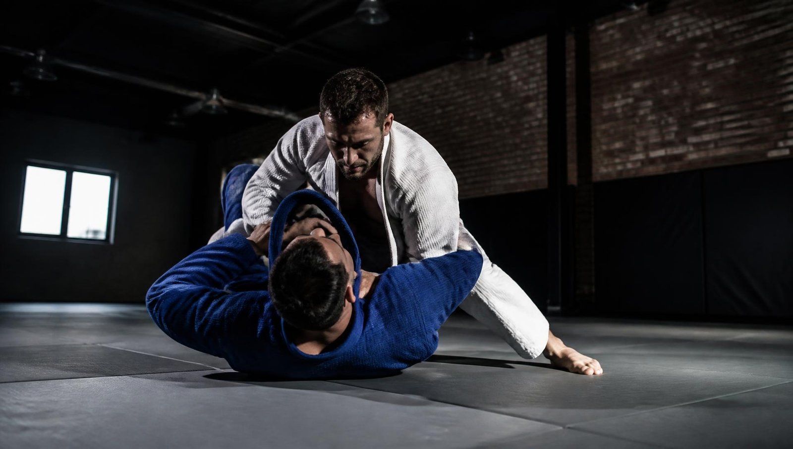 Dupla treinando Brazilian Jiu-Jitsu de kimono sobre o tatame